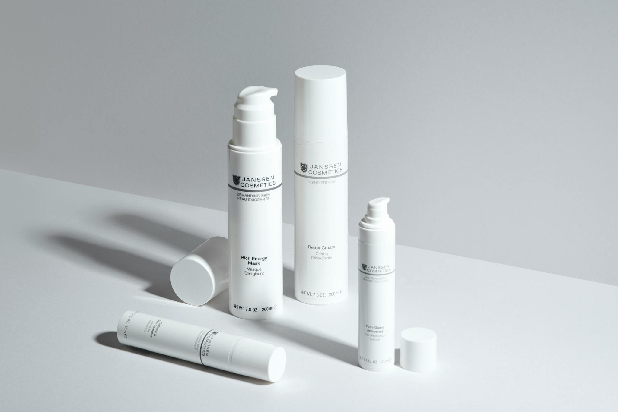 A minimalistic display of skincare bottles showcasing Janssen Cosmetics with a clean white backdrop.