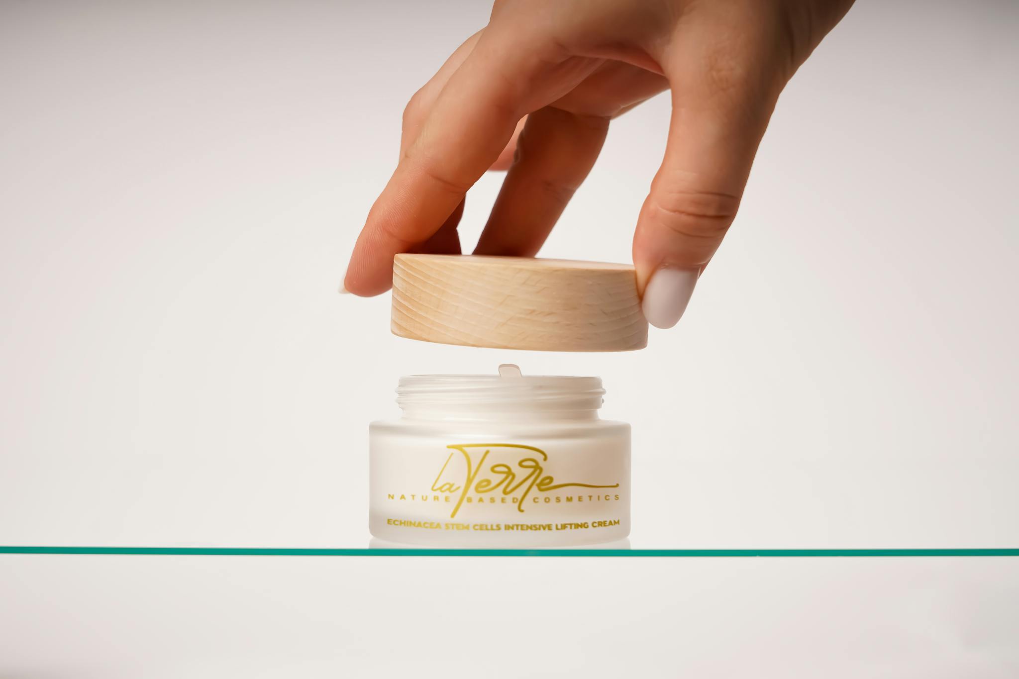 Hand opening Echinacea stem cells lifting cream in minimalist setting.