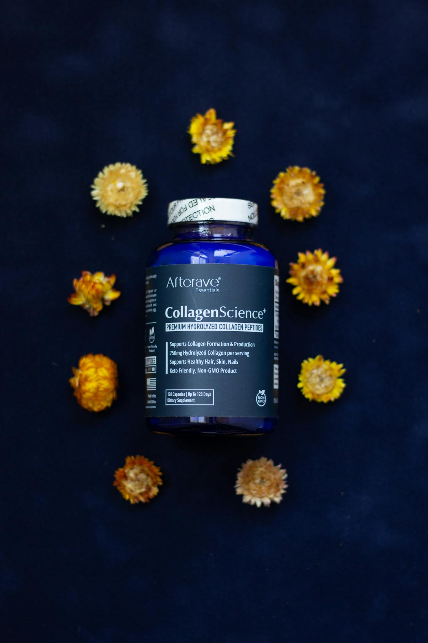 Premium collagen peptide supplement surrounded by dried flowers on a dark background.